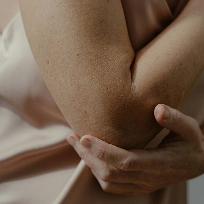 hand touching elbow