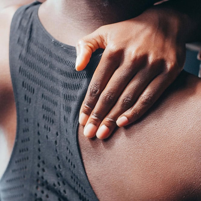 Woman holding her shoulder in pain