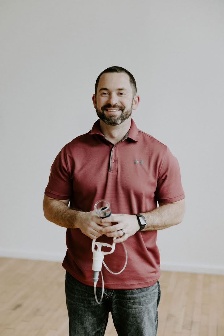 Chiropractor holding equipment used for dynamic cupping therapy as part of a soft tissue treatment approach.
