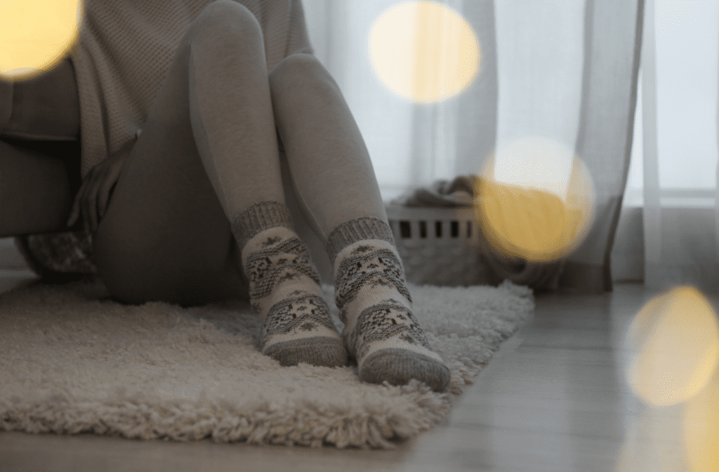 Person sitting alone on the floor in soft lighting, symbolizing trauma that didn’t look like trauma while growing up in a family.