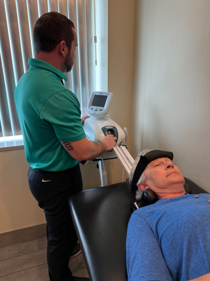 Chiropractor performing cervical spinal decompression therapy on patient using a motorized traction table at Redbird Wellness.