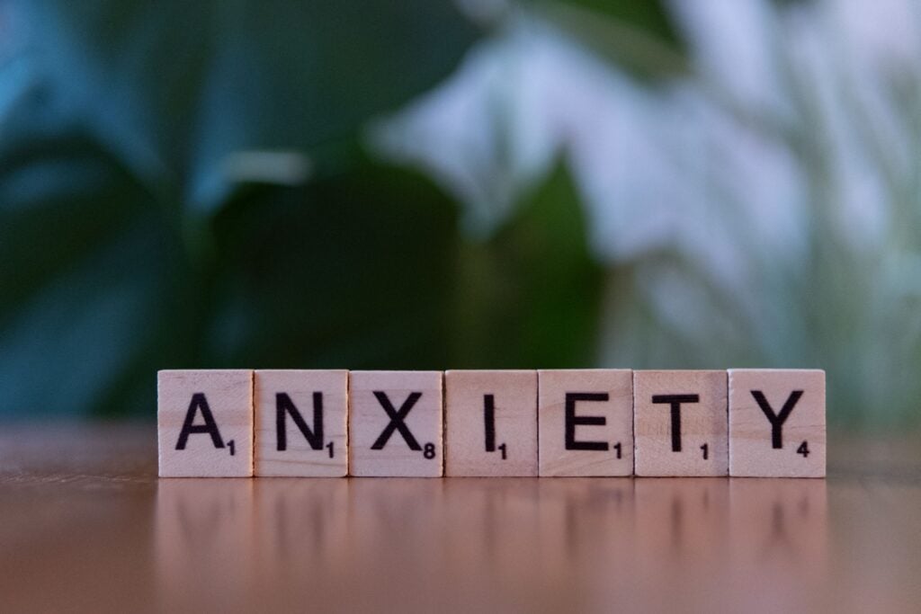 Wooden letter tiles spelling anxiety, representing the internal stress and overthinking associated with high-functioning anxiety.