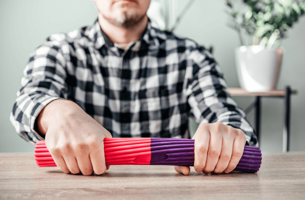 Man using a resistance bar for grip and forearm strengthening exercises as part of carpal tunnel rehabilitation.