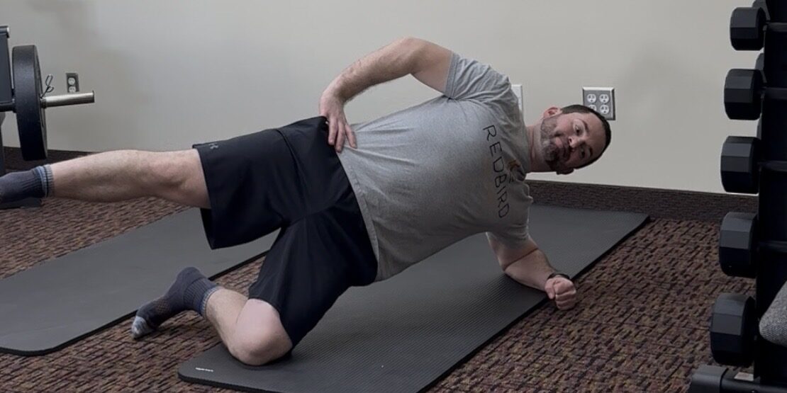 Rehab exercise targeting lateral core strength and hip stability during a modified side plank variation.
