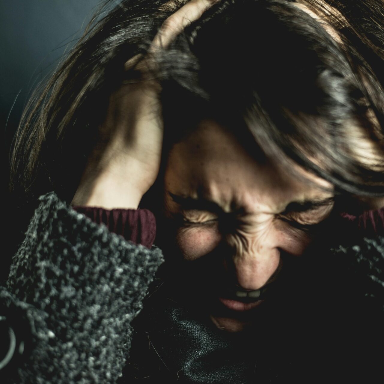 Person holding head in distress, illustrating intense trauma and emotional pain.
